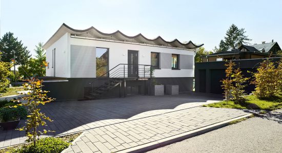 Bungalow Typ Luckenwalde nach der Modernisierung. Fassadengestaltung in grau, weiß und anthrazit, neuer Garagenbau.