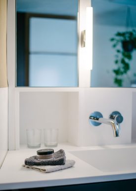 Detail eines Waschtischs mit Spiegelschrank aus weißem Mineralwerkstoff