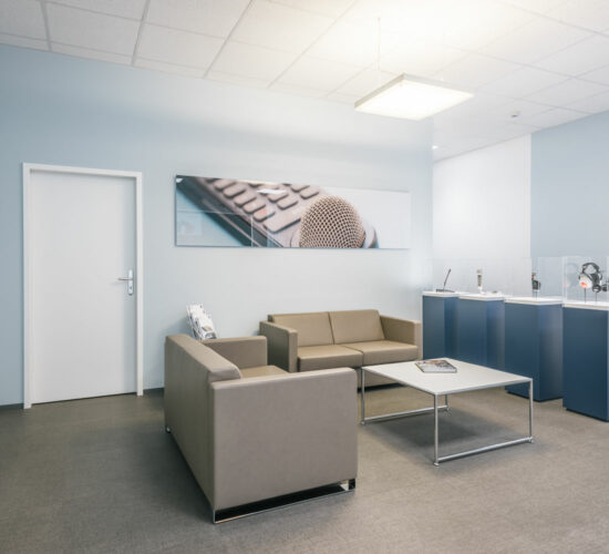 Wartebereich mit Sofas und Produkt-Vitrinen, geplant von raumdeuter, Innenarchitekt in Berlin