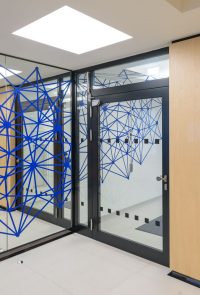 blaues Netzmotiv als Wegeleitung vom Aufzugsvorraum zum Empfang