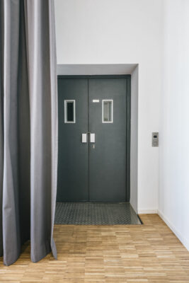 Der Aufzugszugang wird vom Vorhang verdeckt, geplant von raumdeuter, Ihrem Innenarchitekt in Berlin