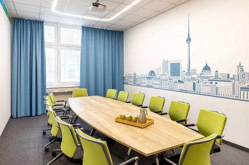 Konferenzraum mit bootsförmigen Tisch und farblich abgestimmten Vorhängen und Bildtapete
