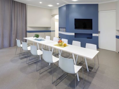 Veranstaltungsraum mit Besprechungstisch und blauer Wand