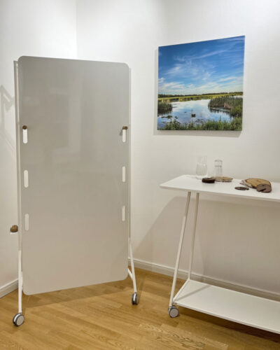 Workshop-Möbel in weiß. Rollbares Whiteboard und rollbarer Stehtisch. An der Wand eine Wasserlandschaft.
